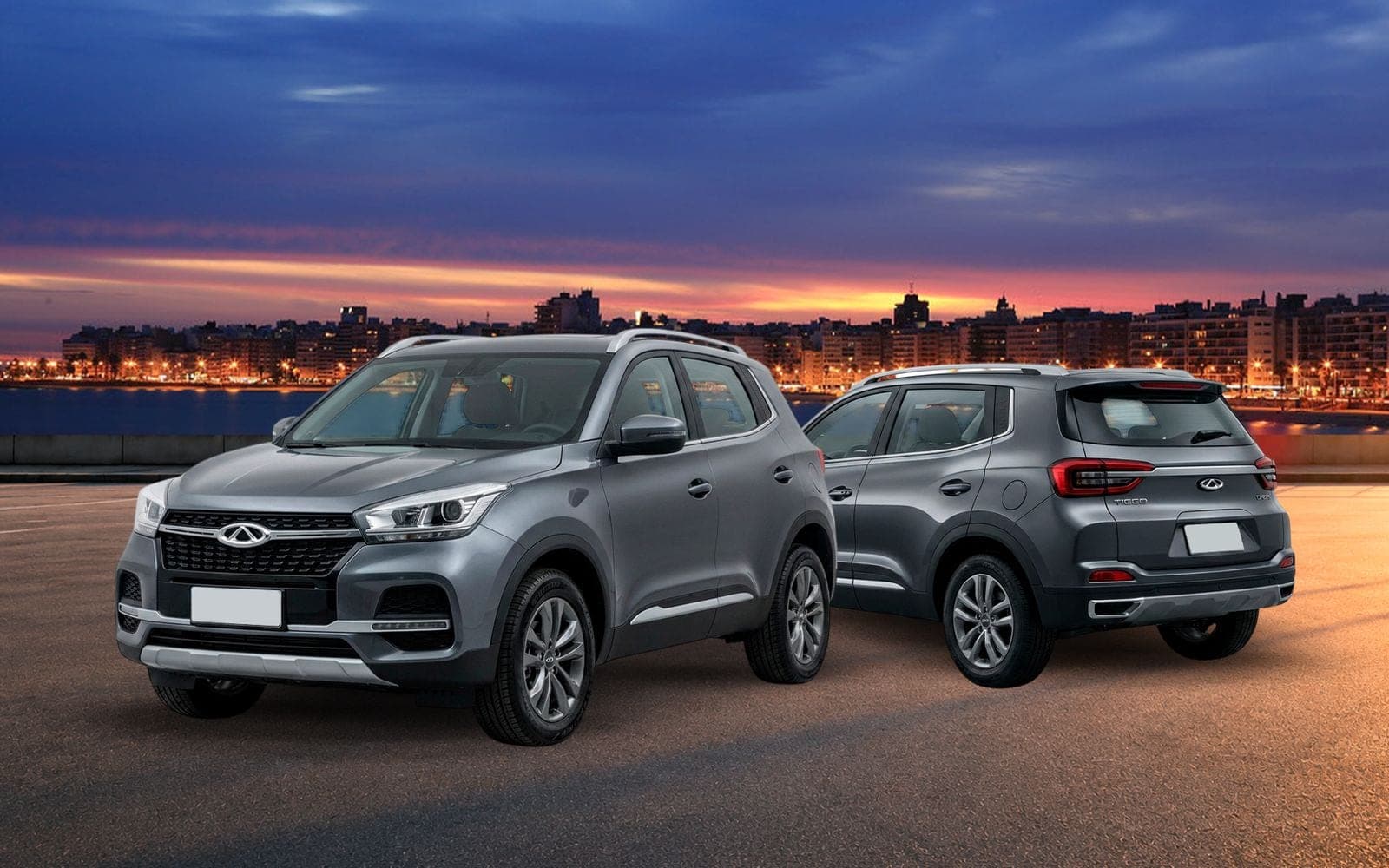 Chery Tiggo 4 gris, de frente y de atrás, con la costa de Montevideo iluminada al anochecer detrás